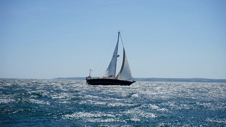 A sailboat sailing on the water in calm weather.